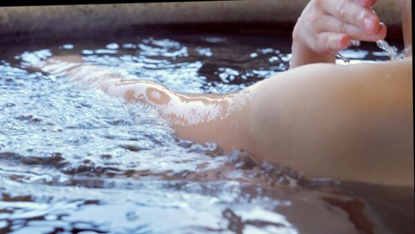 温泉に入っている人の腕の一部の画像